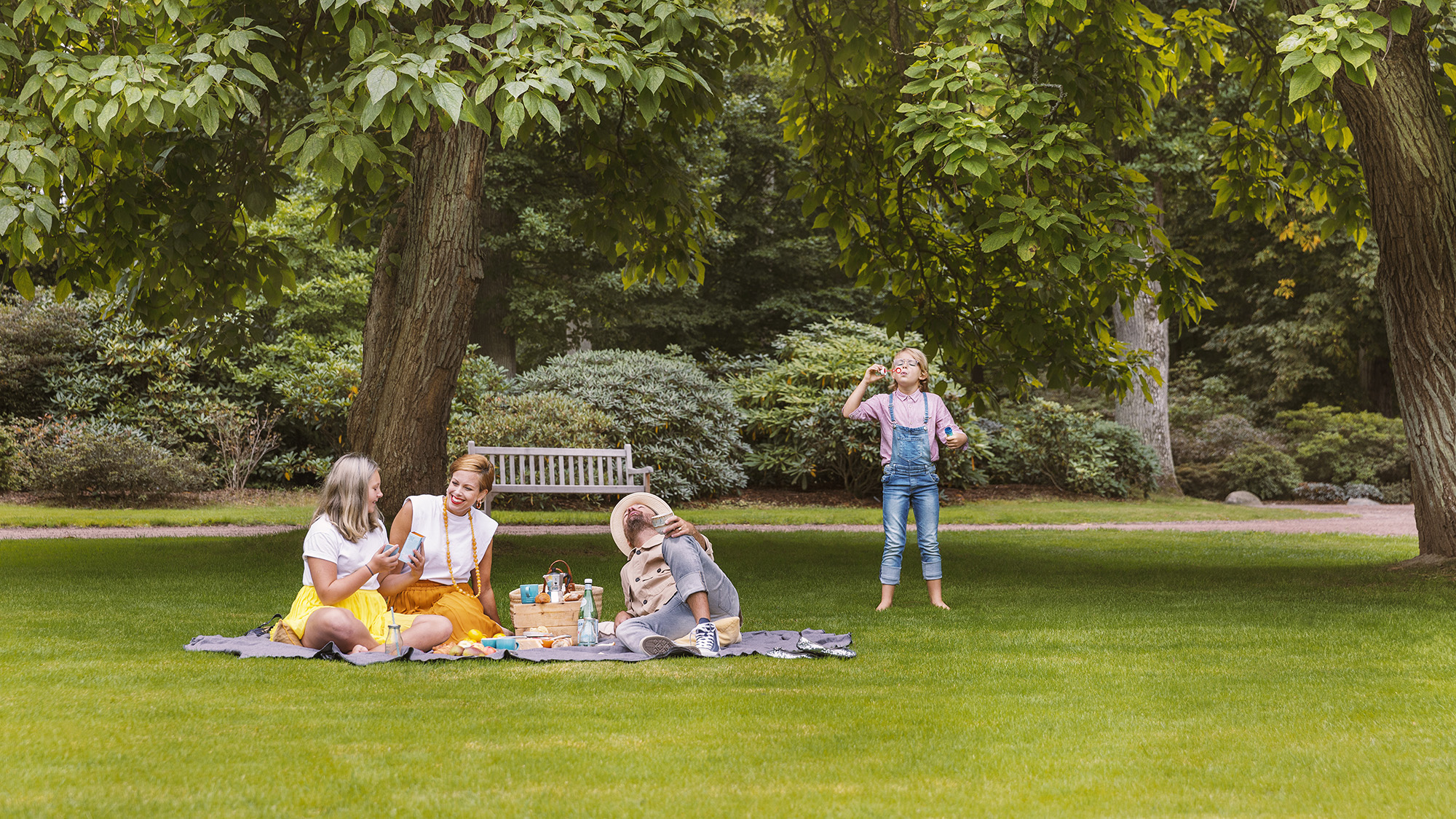 Familj som har picknick på gräsmatta.